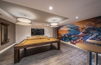 resident social lounge with a pool table and a mural on the wall